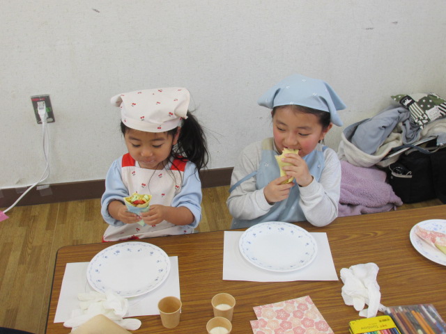 姉妹でおいしそうにクレープを食べている写真