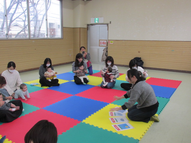 乳児さんをだっこして車座に座っている写真