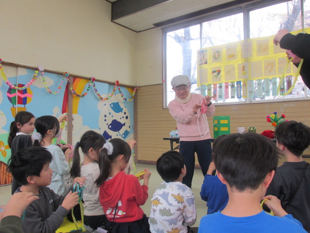 輪っかを使ったマジックを教えてもらっている写真