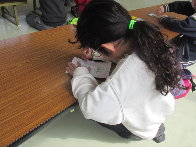 お母さんへのメッセージカードを書いている写真