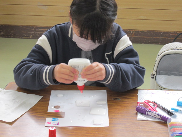 絵の上に木工用ボンドをたらしている写真