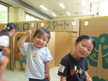 段ボール迷路の入り口で2人の女の子が笑顔でポーズをとっている写真
