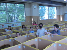 小学生の子供たちがダンボール迷路から顔をだし記念撮影をしている写真