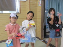 完成した作品と一緒にポーズをとっている3人の女の子の写真