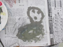 新聞紙に人の顔のようなものを描いた落書きの写真