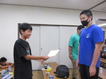 中学生の男の子から賞状を受け取り満面の笑みを浮かべている男の子の写真
