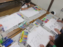 白い紙いっぱいに大きな文字でお店の名前を書いている子どもたちが作成した看板の写真