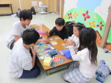 初心者の子どもたちが、主催者のこどもにゲームを教わっている写真