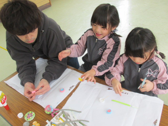 子どもたちの工作をお父さんが見守っている写真
