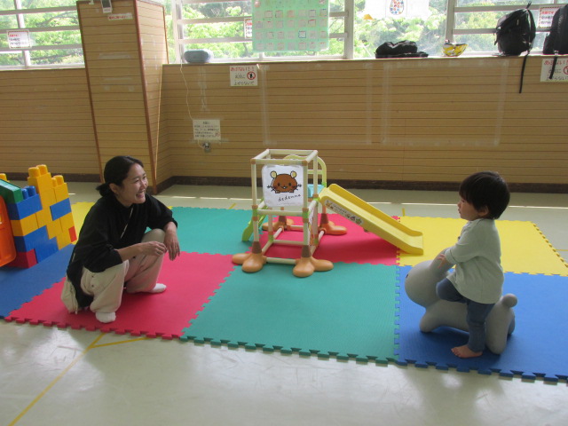 新しいゴム製遊具にまたがって遊ぶ親子の写真