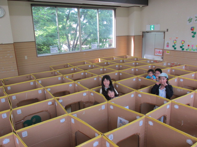 ダンボール迷路からみんな顔を出している写真