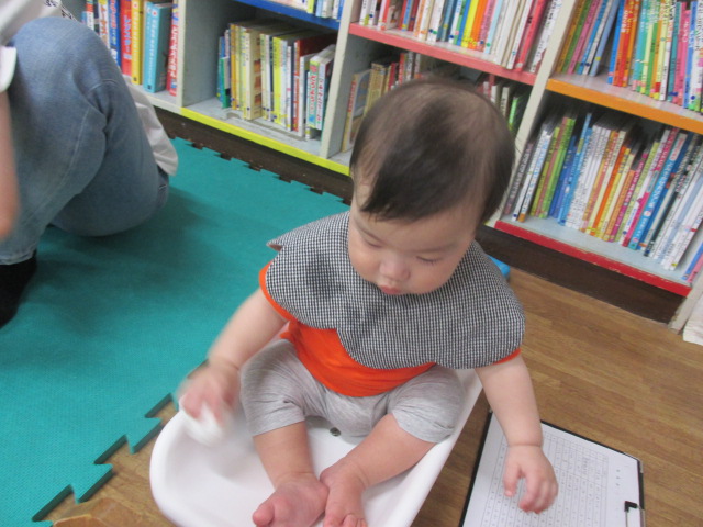 幼児が体重計にお座りで乗っている写真