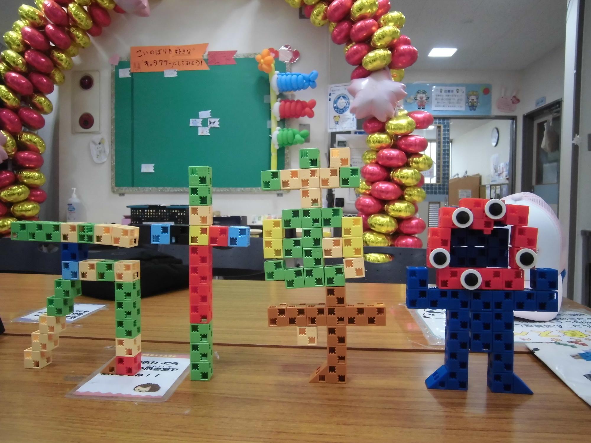 アーテックブロックで作られた「万博」の文字とキャラクターを並べて撮った写真。