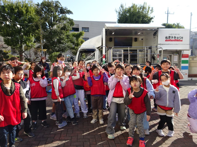 起震車の前でポーズをする子どもたちの写真