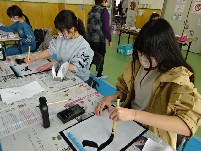 実際に書初めをする子どもたちの写真