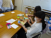 長机に向かった女の子たちが、メッセージカードの組み合わせを選んだり実際にメッセージを書き込んでいる写真