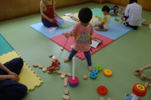 片手に持ったおもちゃと一緒に散歩する女の子の後ろ姿を撮影している写真