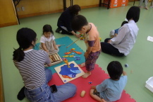 ブロックで作られた魚釣りのおもちゃに夢中になって遊ぶ男の子の写真