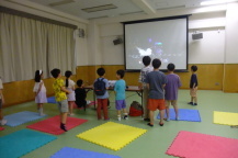 ゲームが楽しくて立ち上がってしまう子供たちの写真
