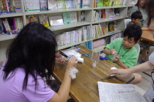 テーブルに対面で座った2名の子どもがペットボトルで制作を行っている写真