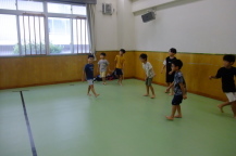 黒い線の内側で複数名のこどもたちがボールの行方を追うように同じ視線を向けている様子の写真