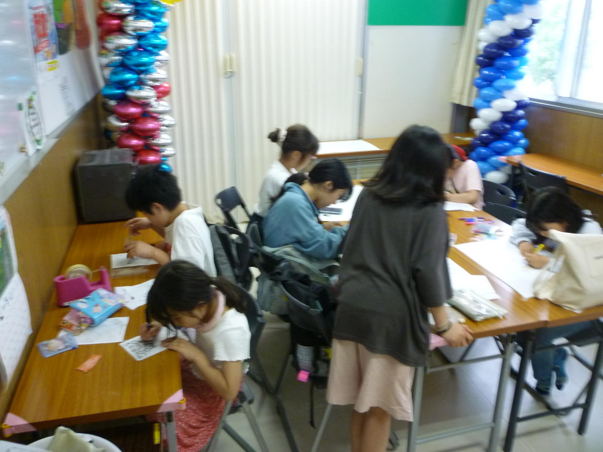プラバンに絵を描いているこどもたちの写真