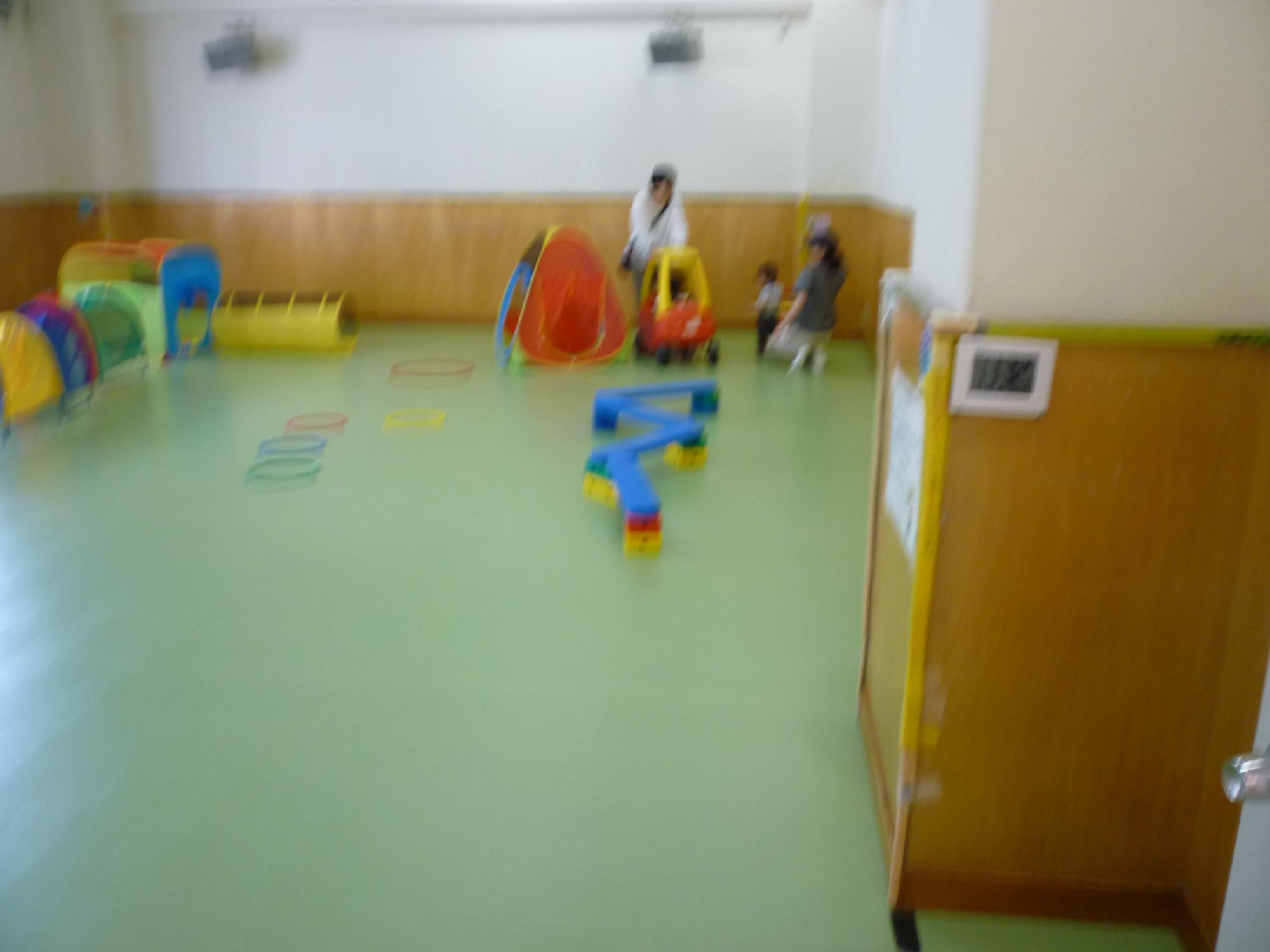 大型遊具で遊ぶ幼児親子たちの写真