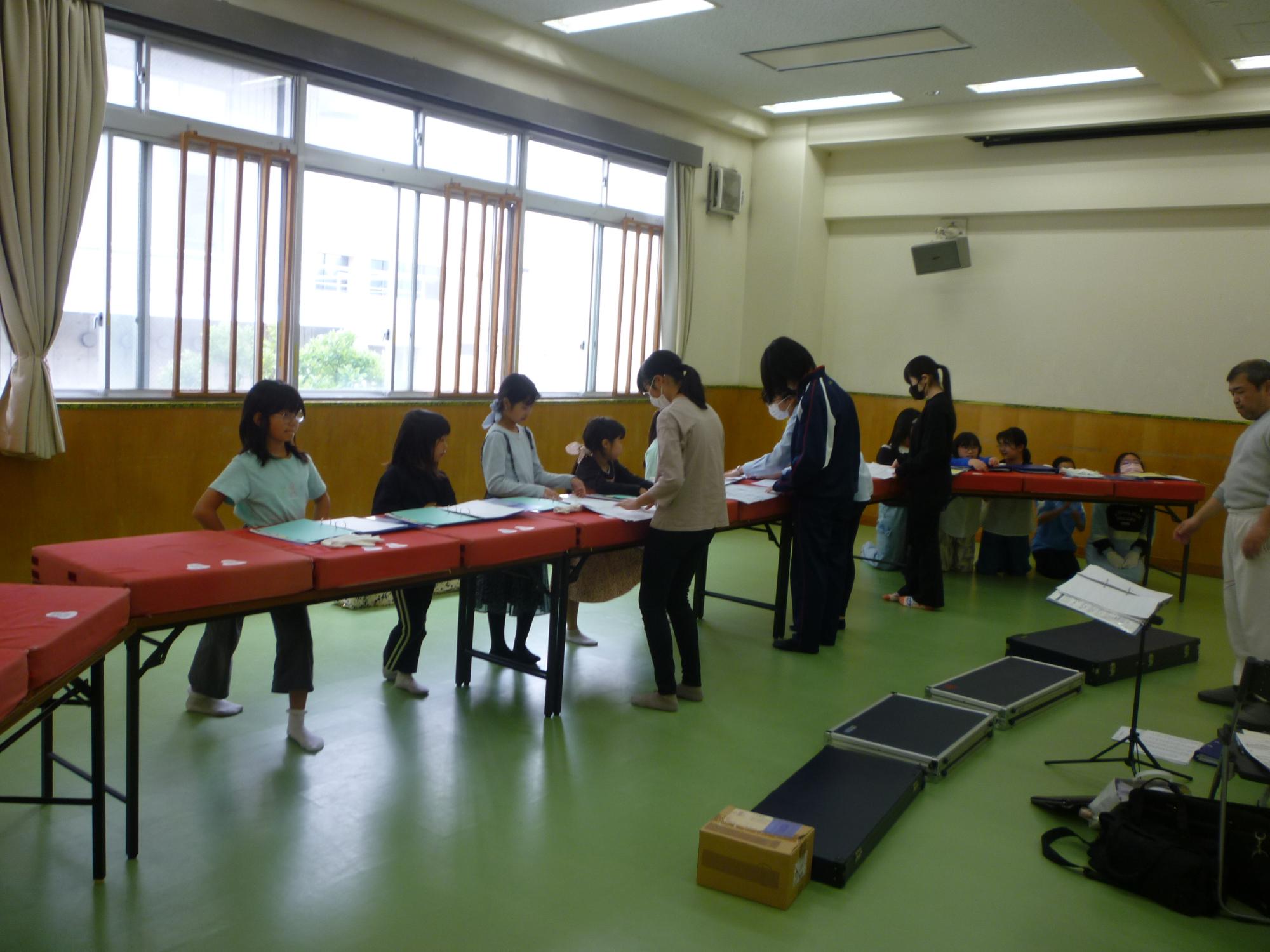 先輩からベルを教わるこどもたちの写真