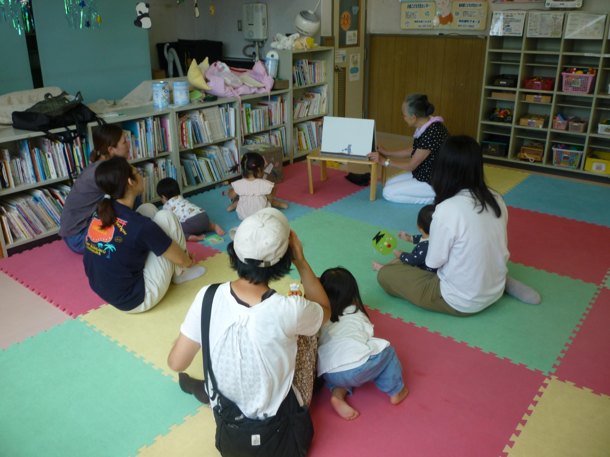 読み聞かせを聞く参加者親子の後ろ姿の写真