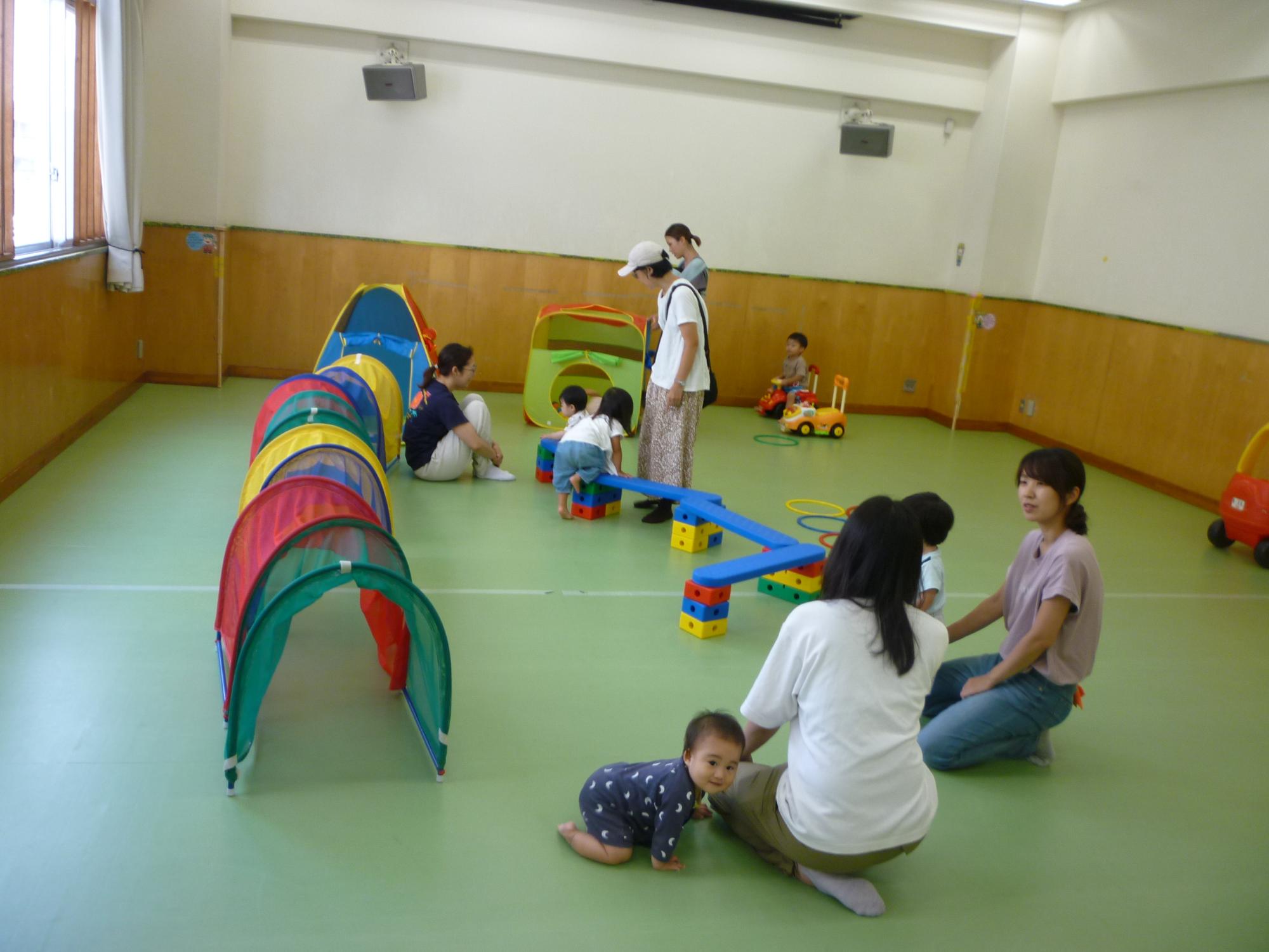大型遊具で遊ぶ幼児親子たちの写真