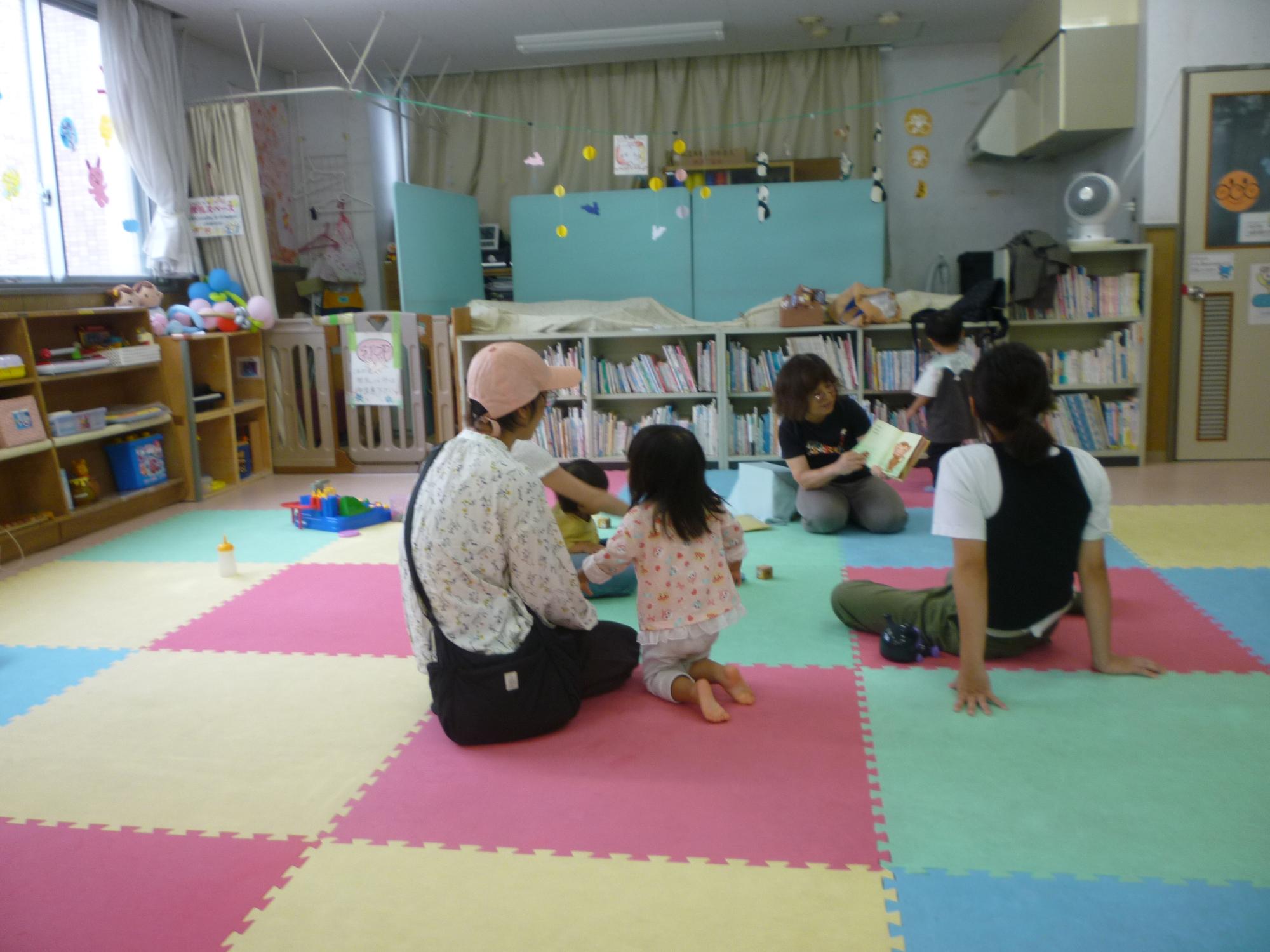 読み聞かせを聞く参加者親子の後ろ姿の写真