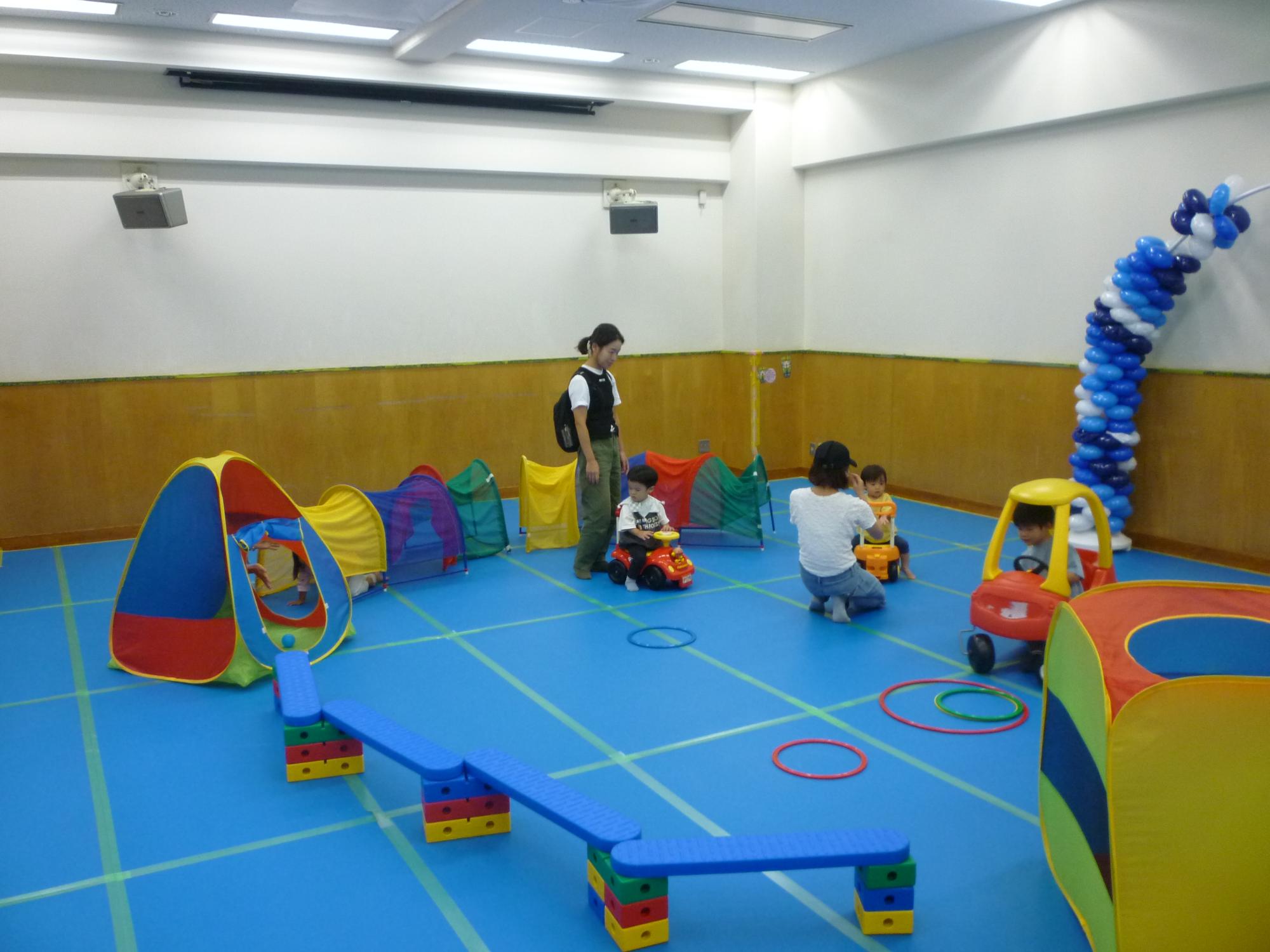 大型遊具で遊ぶ幼児親子たちの写真