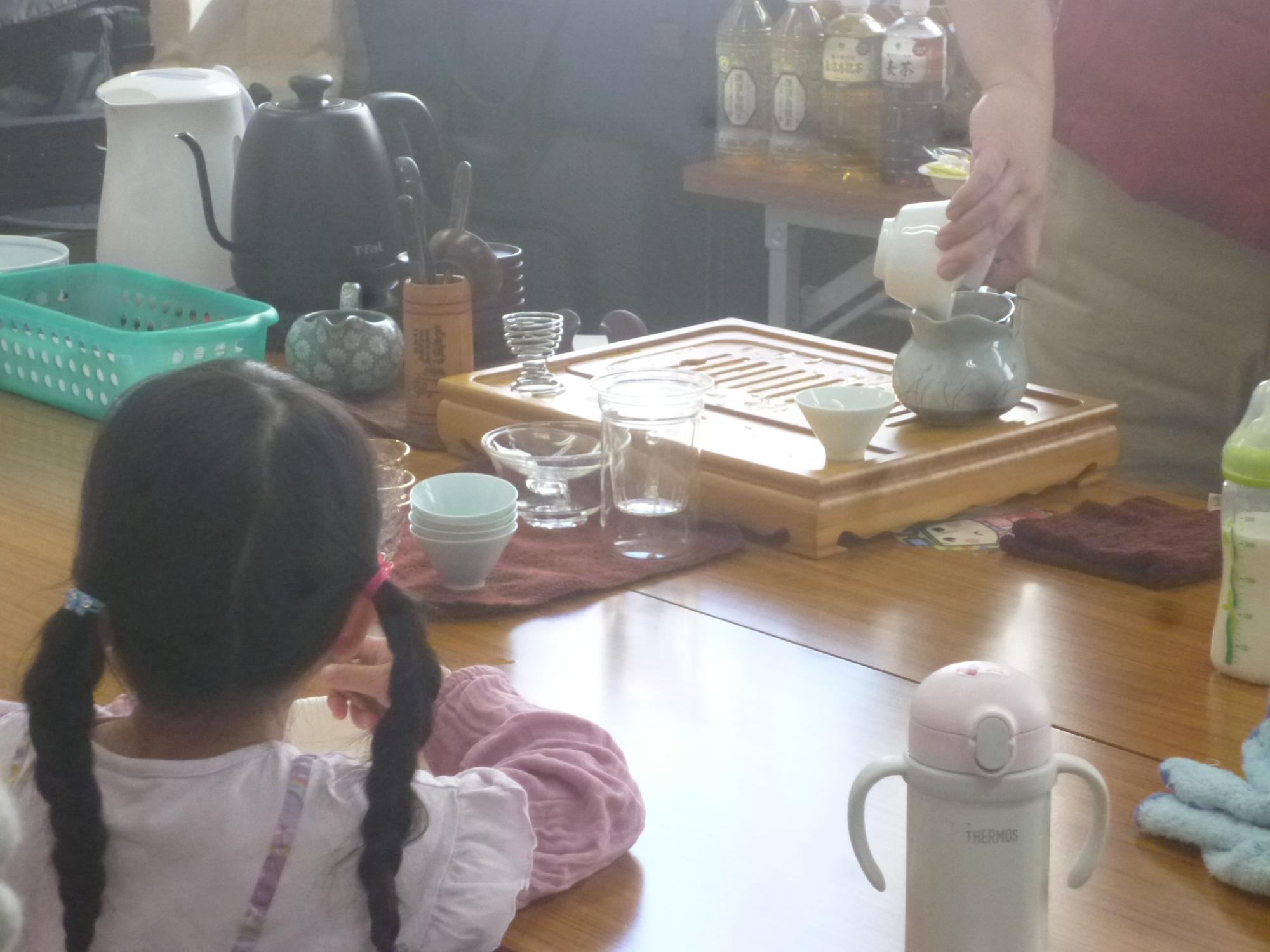 講師がお茶を淹れているところを参加者の子どもが見ている写真。