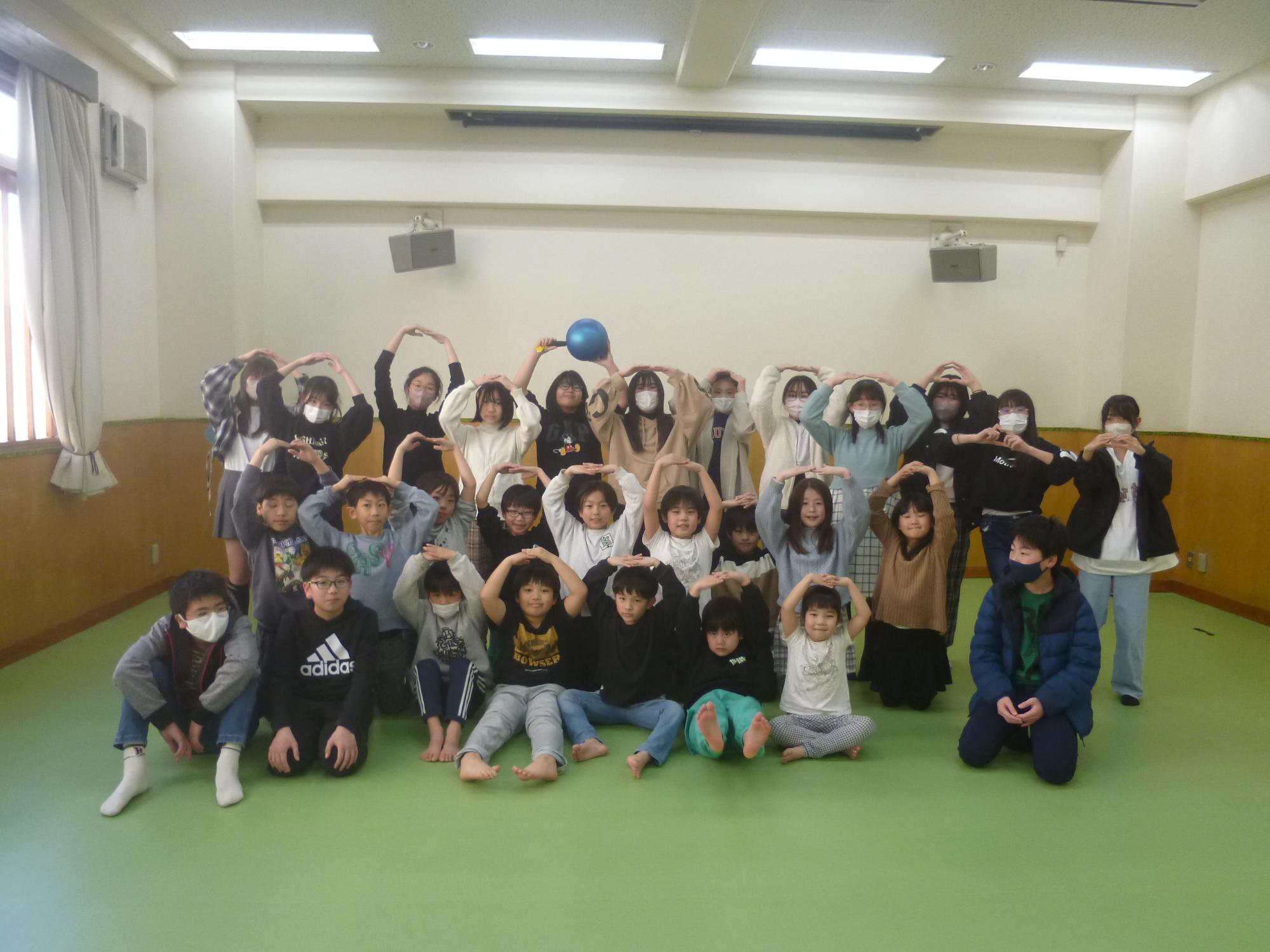 頭の上で丸を作り記念撮影をする参加者の写真