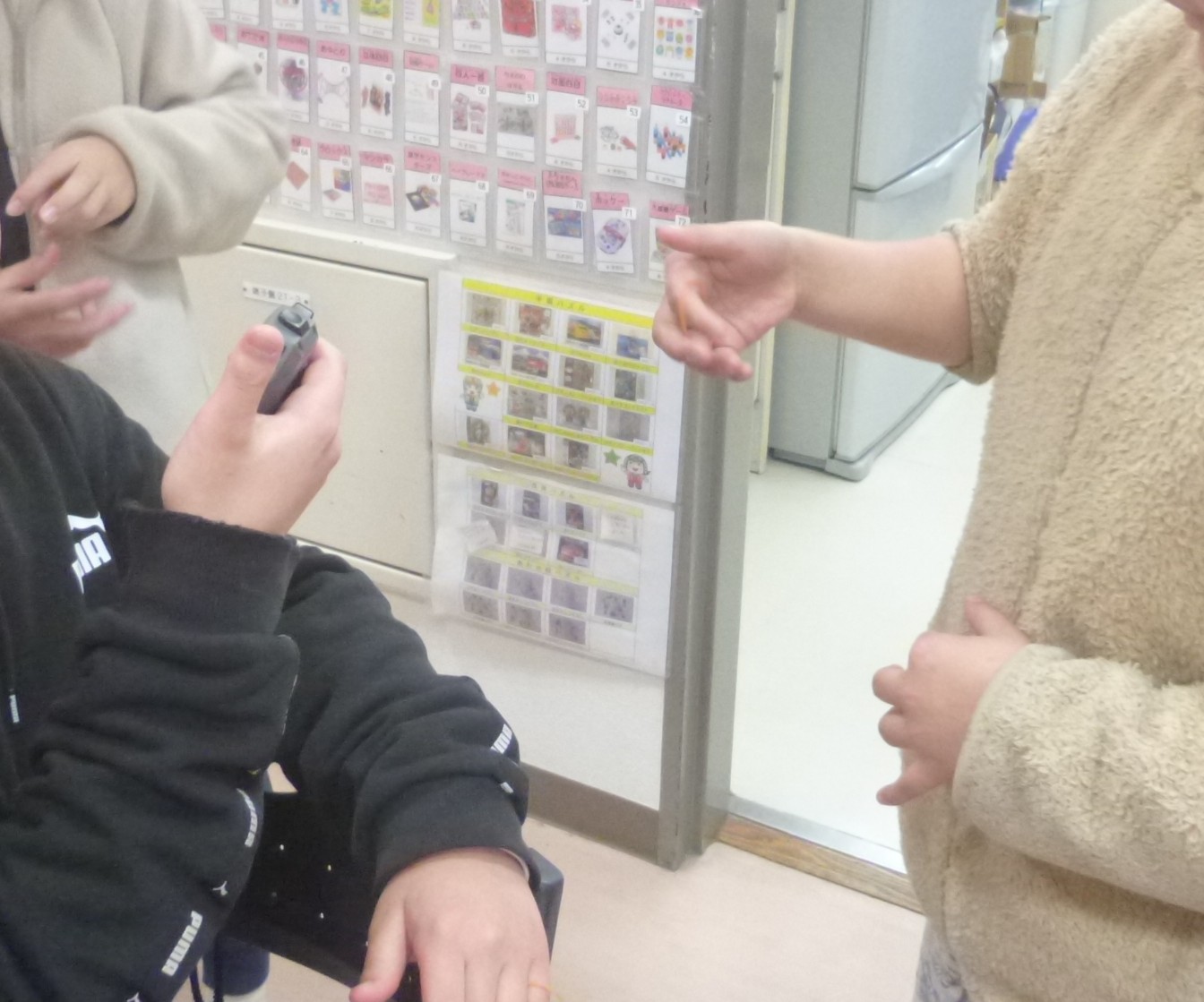 指ゴム渡しに挑戦する子どもの写真