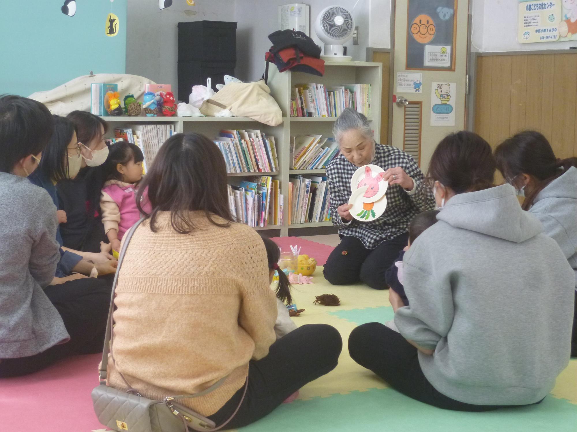 手遊びの様子を見ている参加者親子の写真
