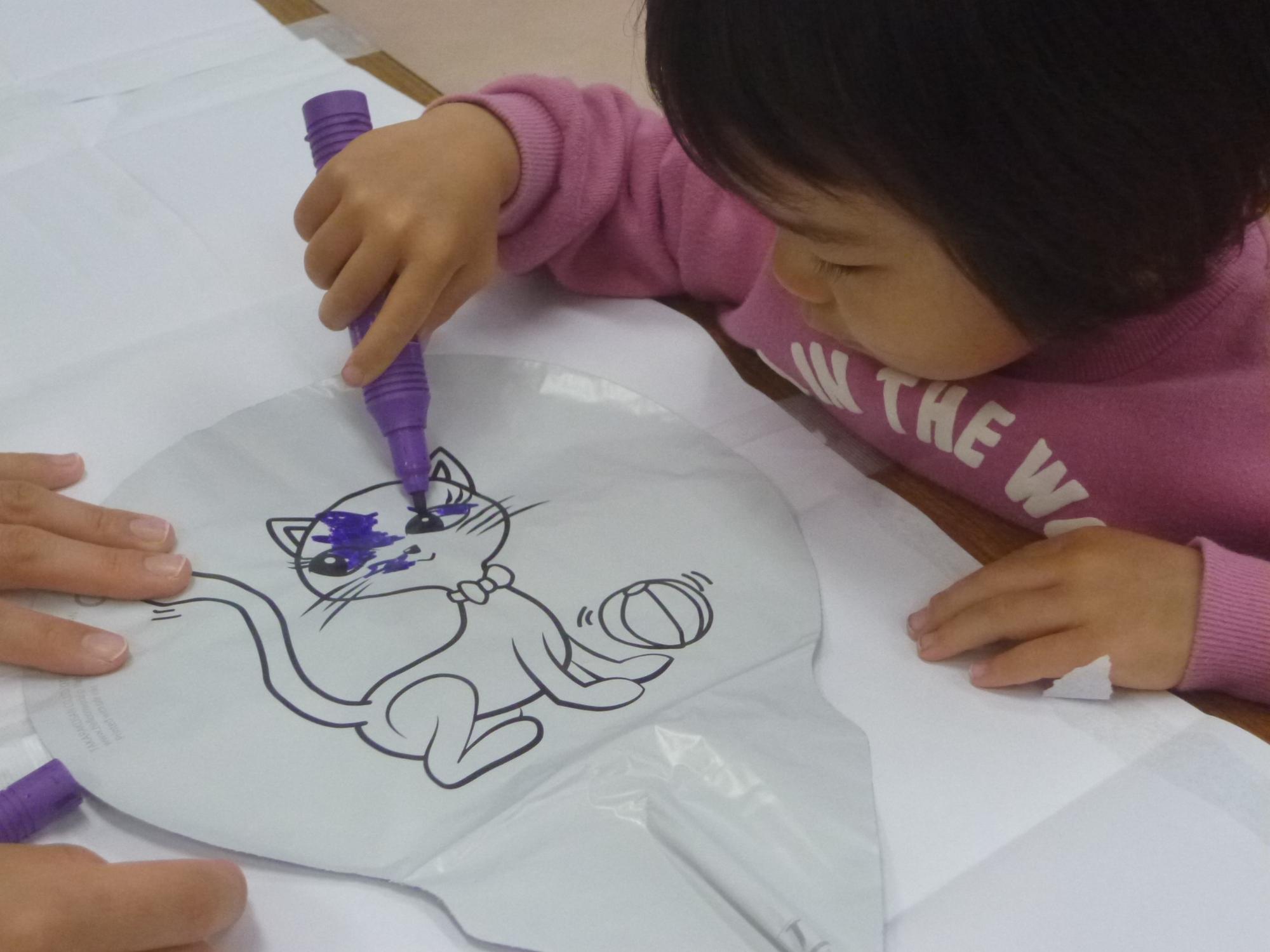 バルーンアートに色を塗る幼児さん