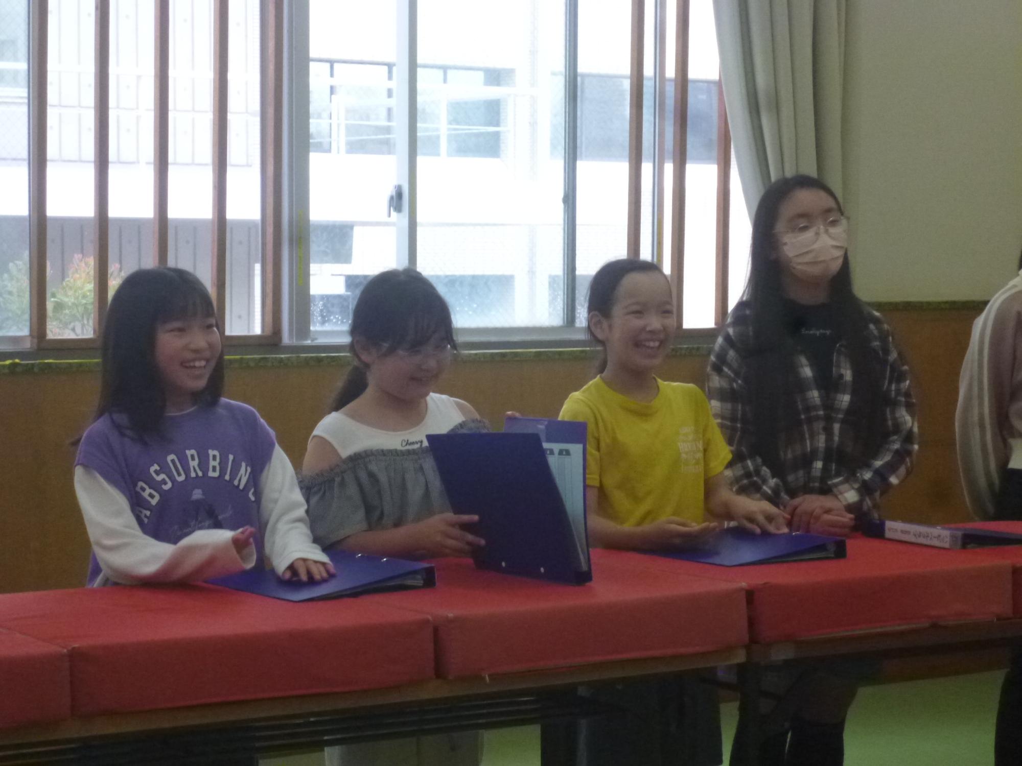 「幸ハッピーベルクラブ」で今年度の担当パートの発表を笑顔で聞いている子どもたちの写真