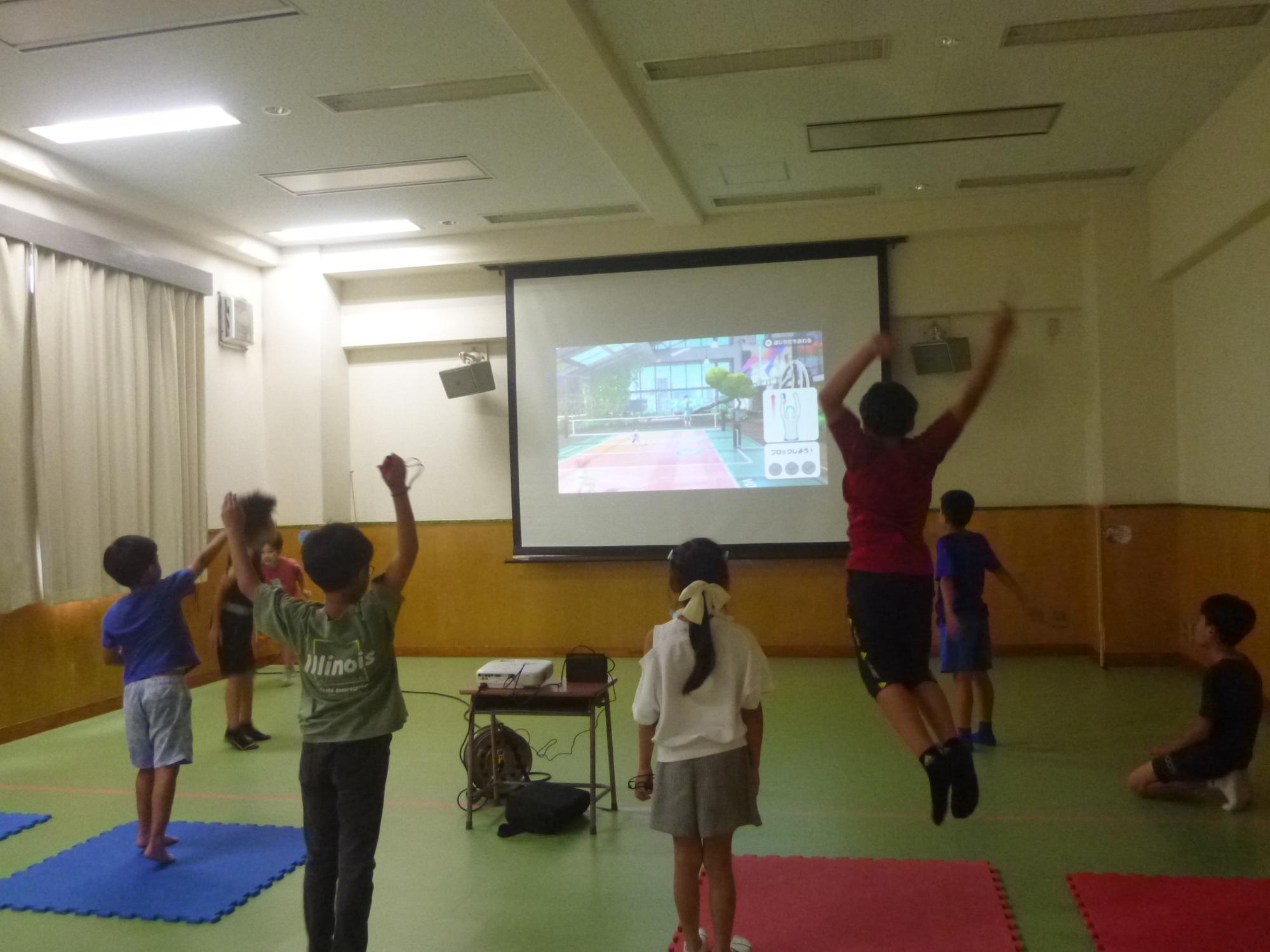「やってみよう！eスポーツ」、体感型スポーツゲームに挑戦する小学生の写真