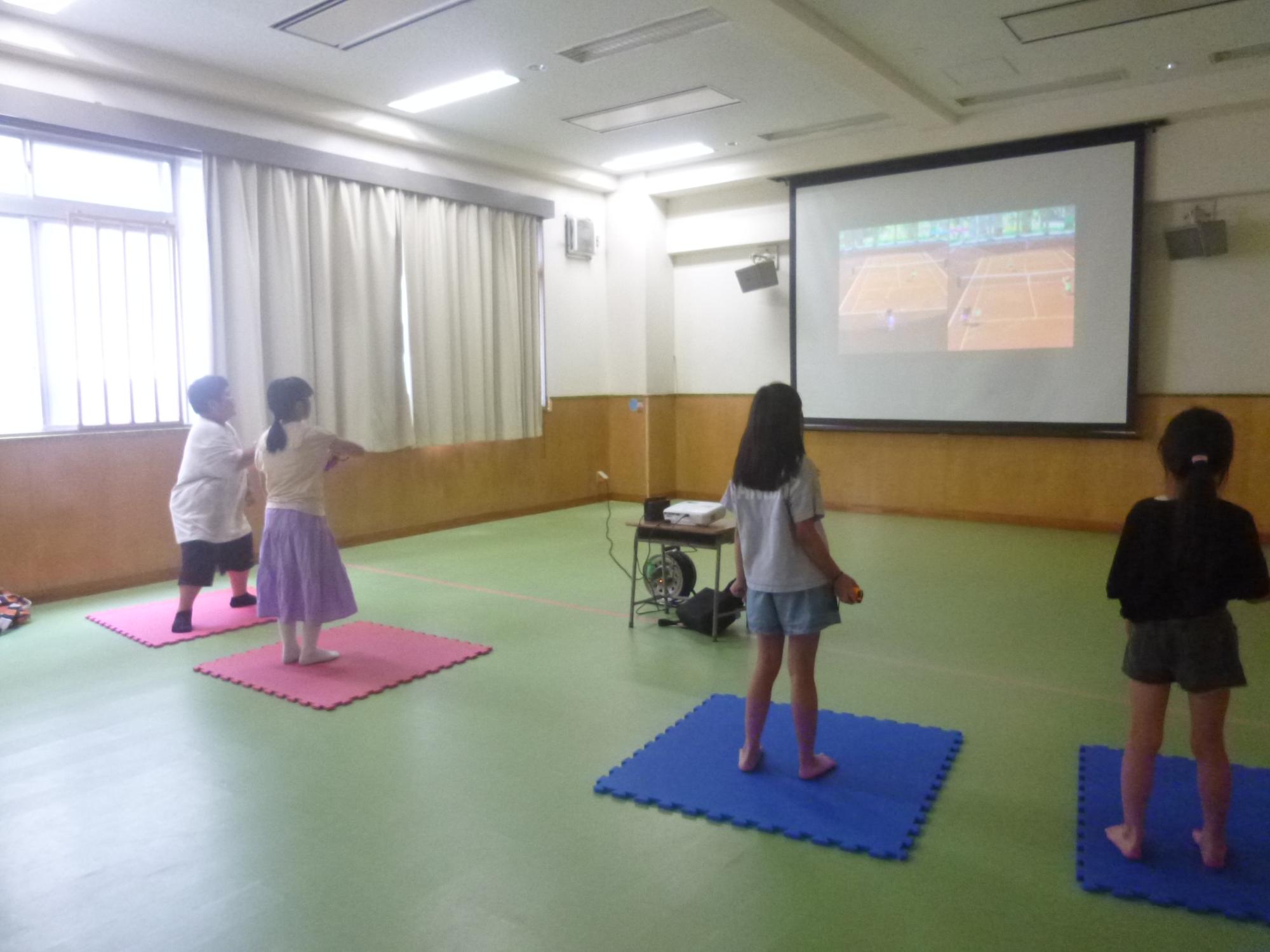「やってみよう！eスポーツ」、体感型スポーツゲームでテニスをする小学生の写真
