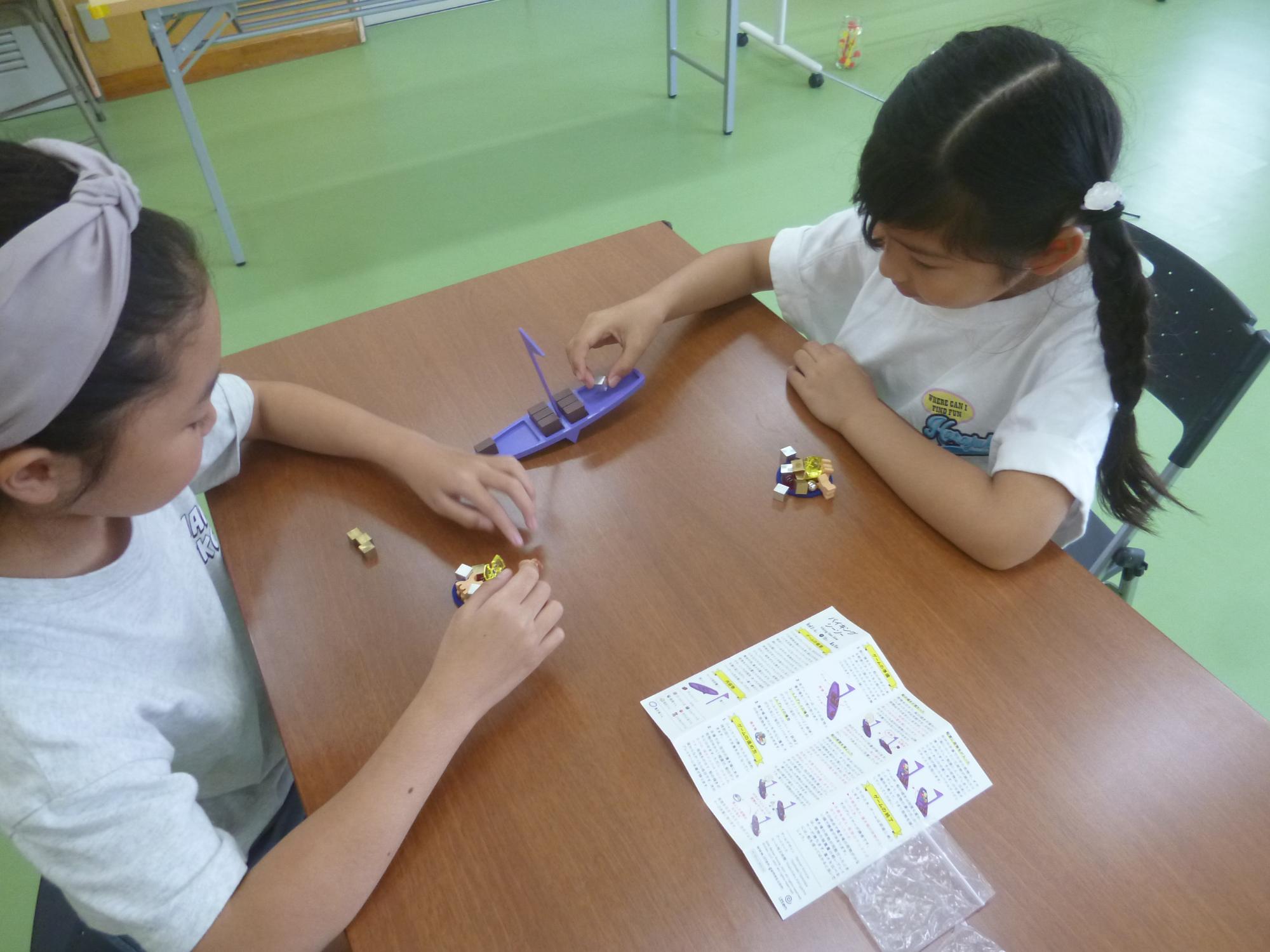「ボードゲームで遊ぼう」バランスを保つボードゲームを遊ぶ小学生の写真