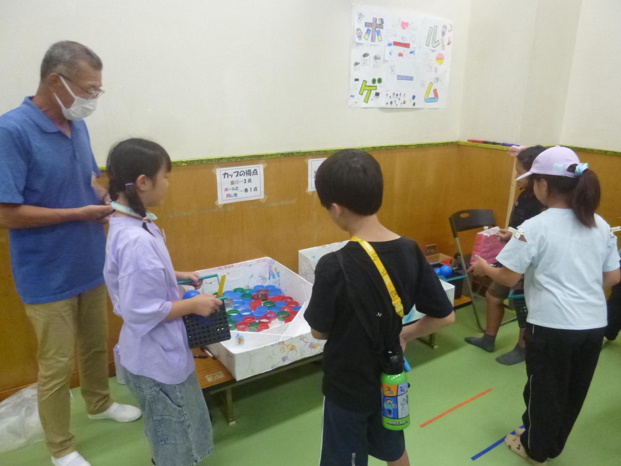 「夕涼み会」、ボールゲームに挑戦する小学生の写真