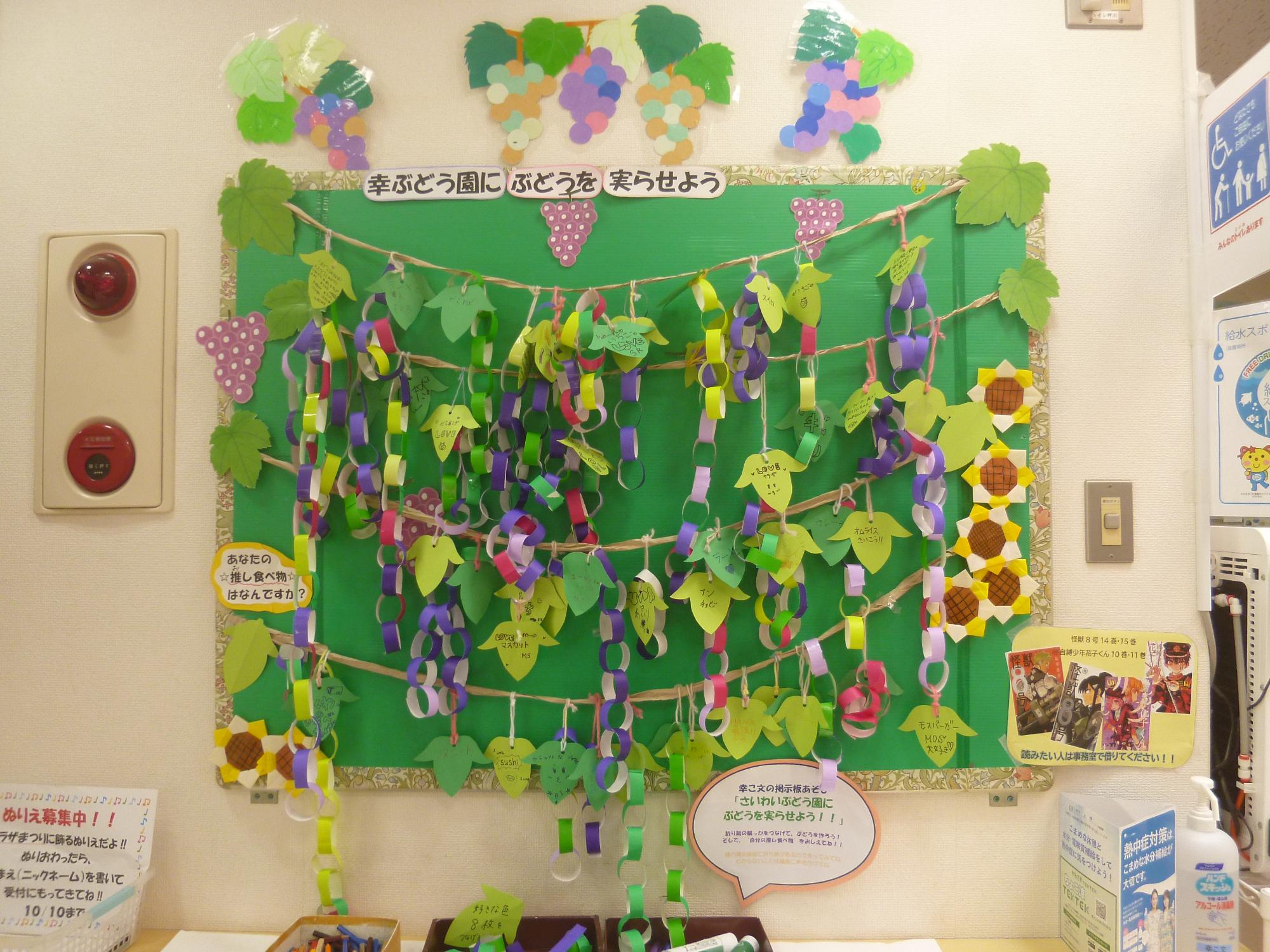 掲示板にぶどうのかざりをつけている画像