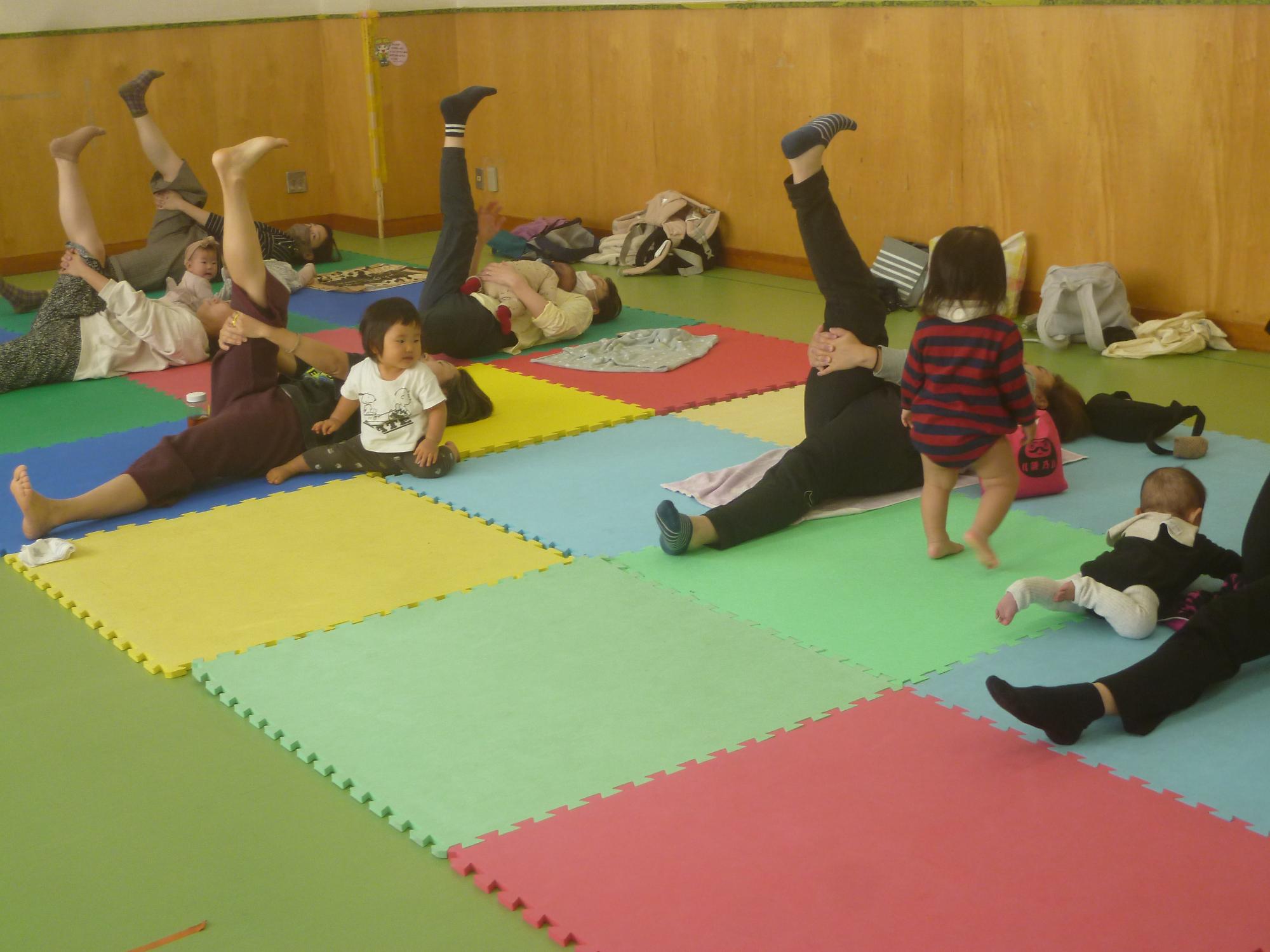 母親がヨガをやっている姿を見ているこどもの様子