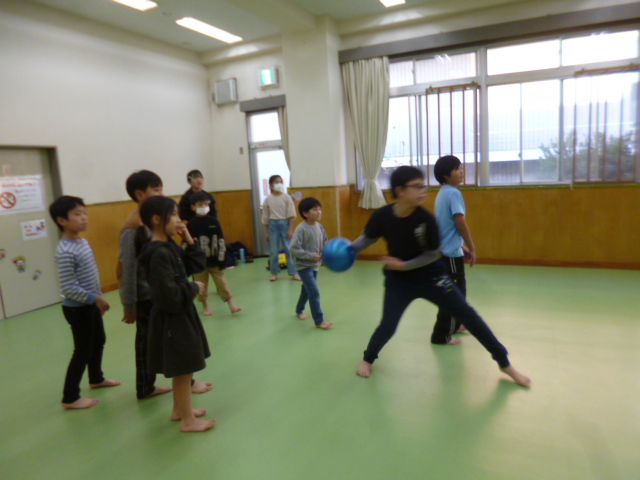 広い部屋の中で楽しそうにドッジボールをする子供たちの写真