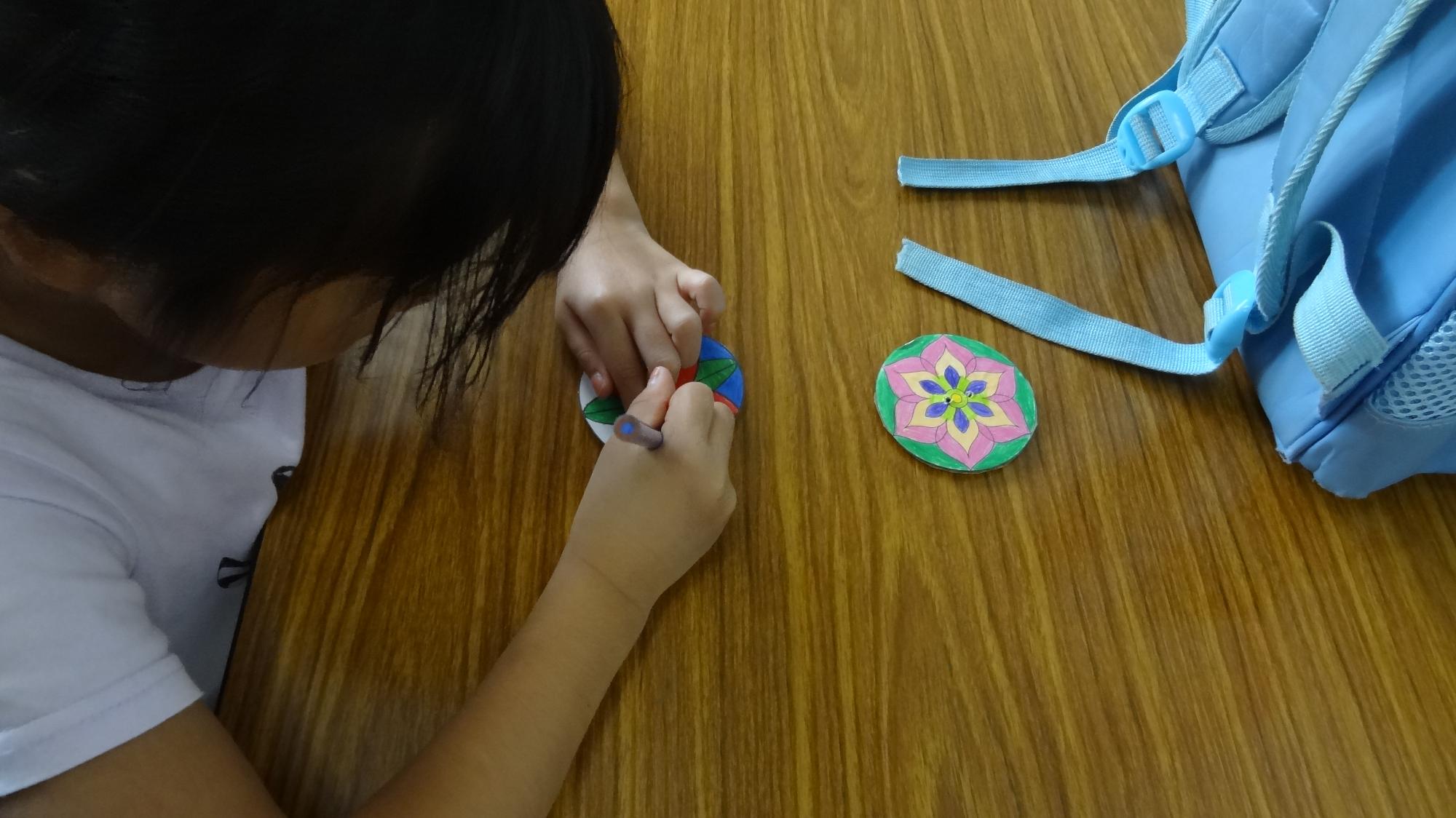 ぶんぶんゴマのイラストに色を塗っている様子