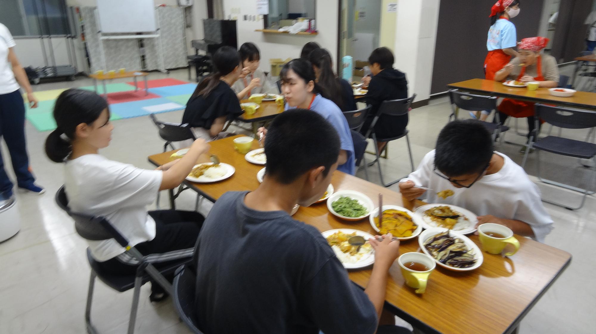参加した中学生が仲良くカレーライスを食べる様子