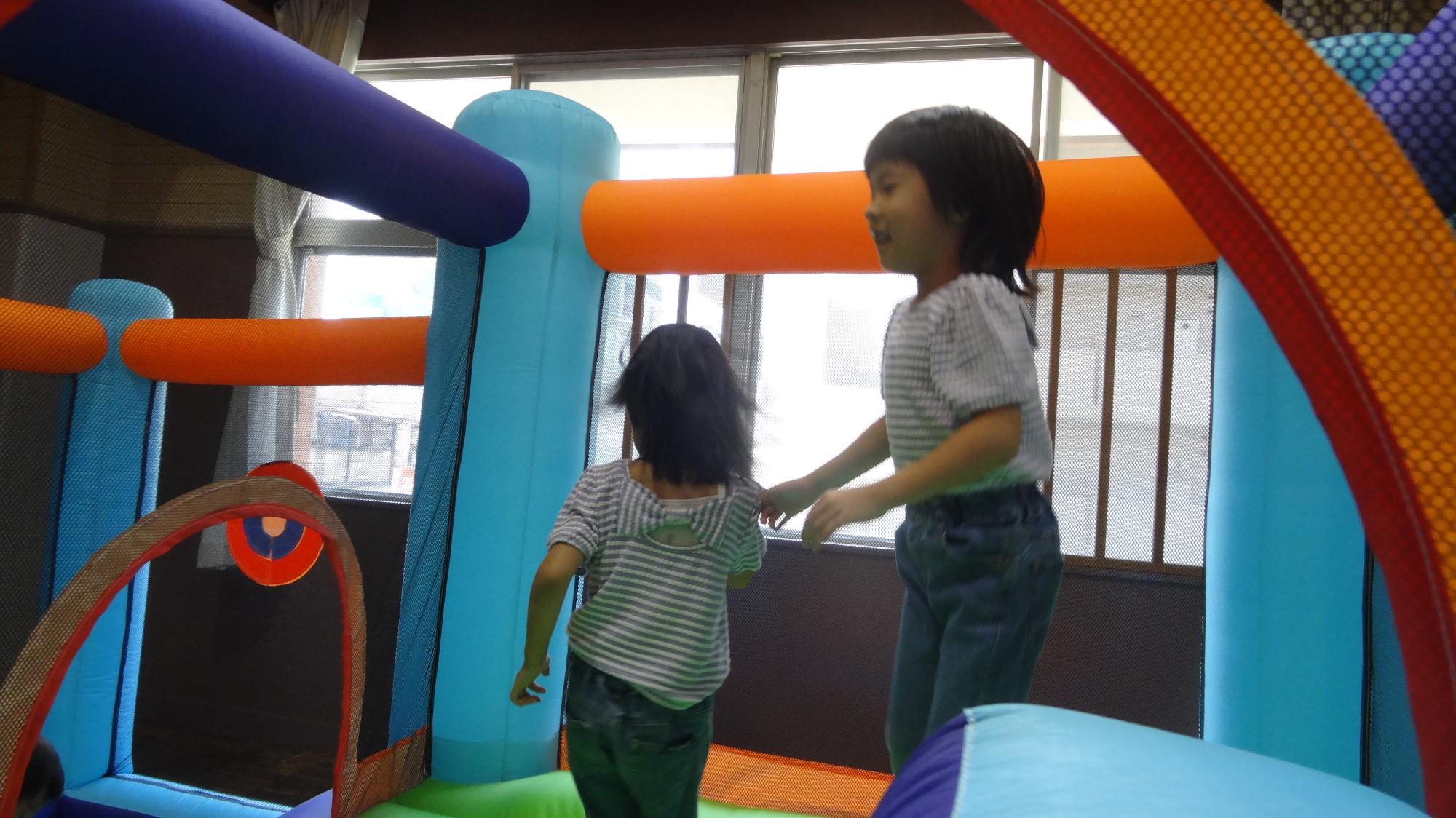 子どもたちがジャンピングスライダーで遊ぶ様子