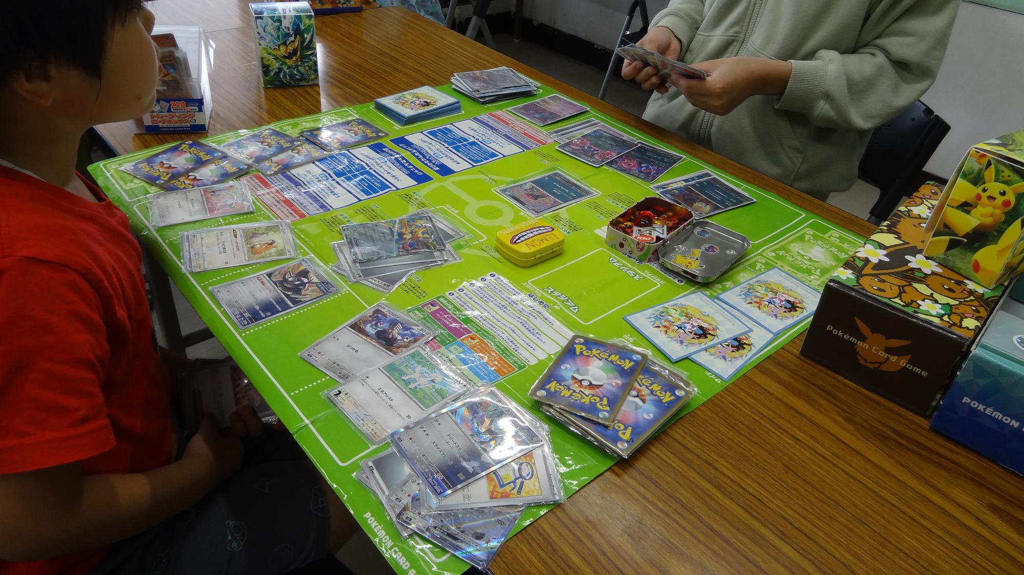 子どもたちがオリジナルポケモンカードを持参し対戦している様子