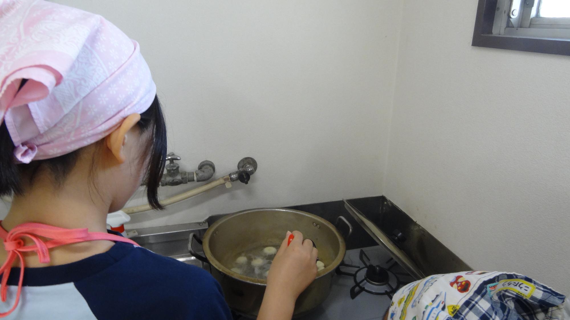 小学生が白玉を鍋でゆでる様子